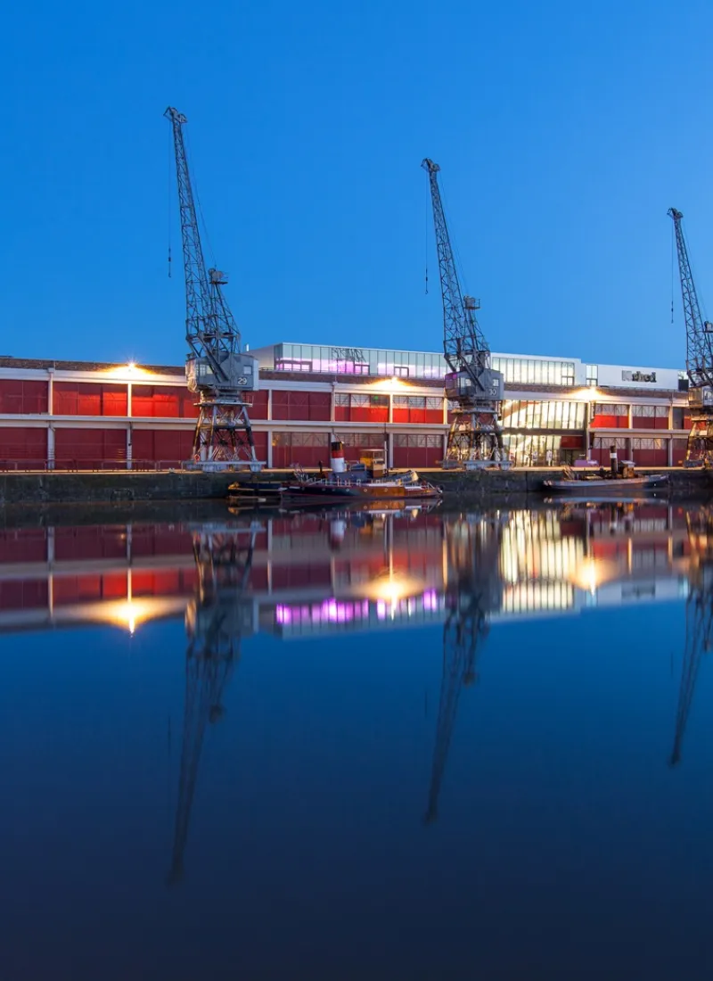 M Shed from water at night